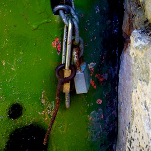 Détail d'une porte en métal vert, pierres, chaines et cadenas - France  - collection de photos clin d'oeil, catégorie portes